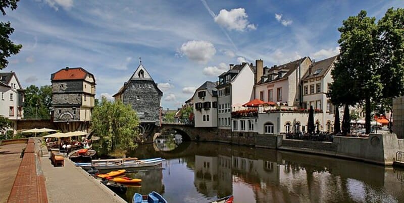 Historische Häuser und Brücke am Fluss mit Booten und Caféterrassen in Bad Kreuznach.