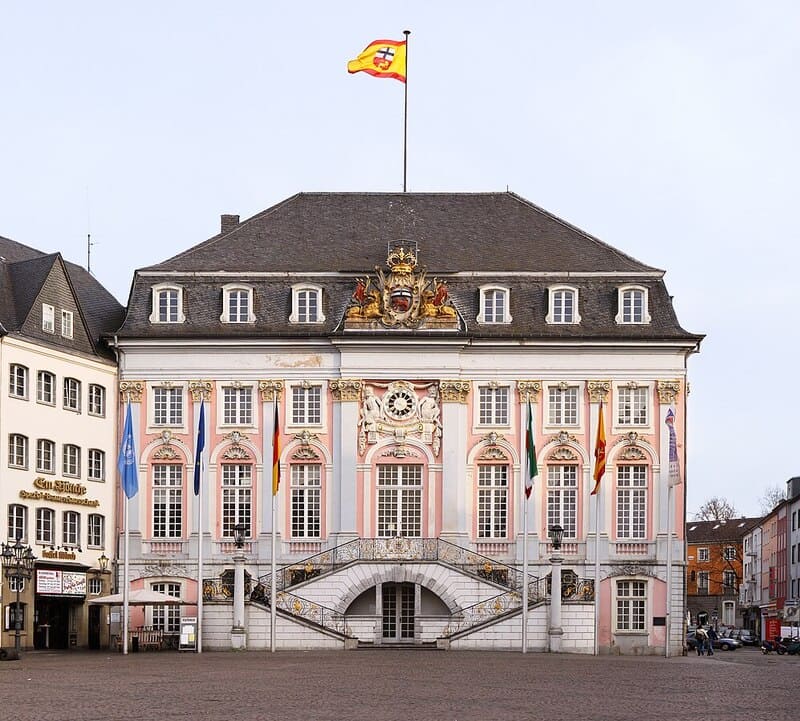 Blick auf das Bonner Rathaus mit verzierten Fenstern und breiter Freitreppe am Marktplatz.