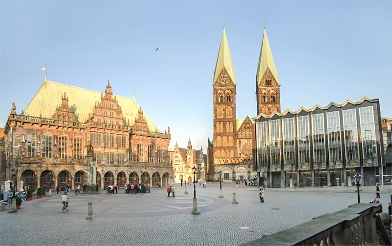 Historischer Platz in Bremen mit Rathausfassade, Doppeltürmen des Doms und modernem Glasgebäude.