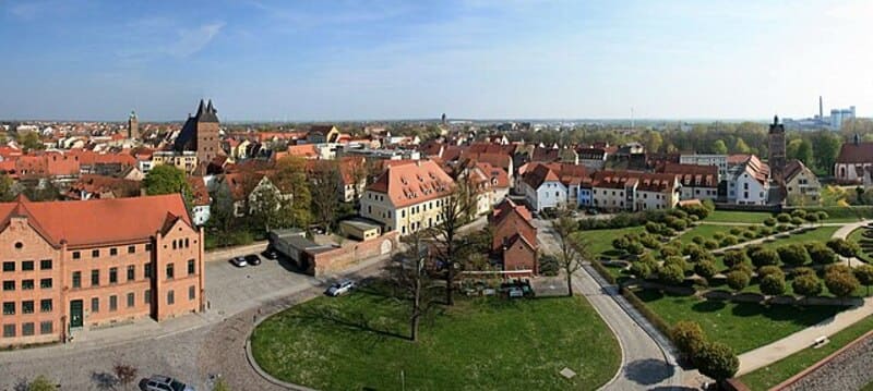 Panorama von Delitzsch mit historischen Häusern, rotem Dachbestand und gepflegten Grünflächen.