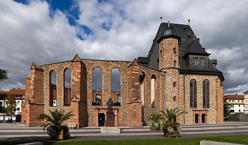Teilweise erhaltene Kirchenruine in Hanau mit hohen Sandsteinbogen und modernem Anbau.