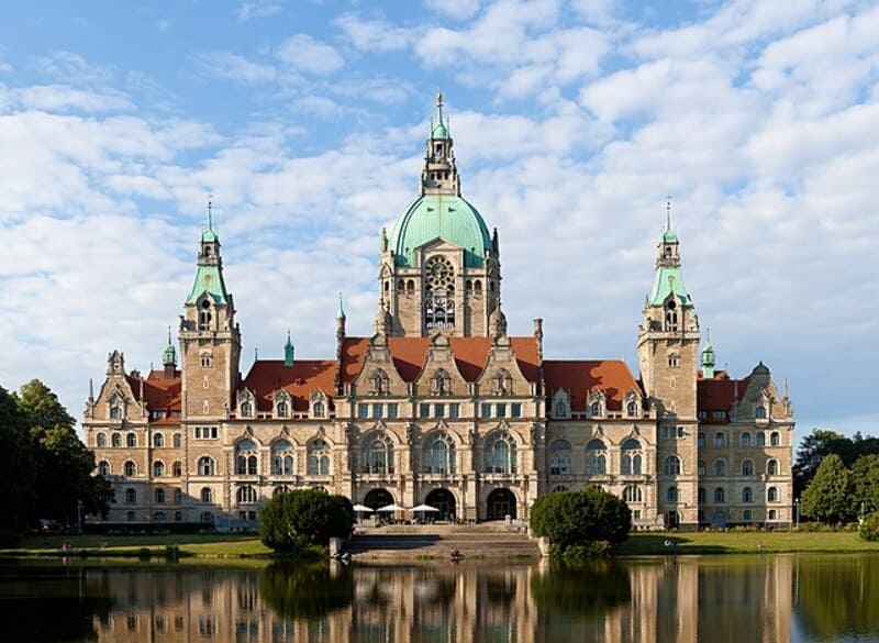 Coreflow-Hannover-Hero Neues Rathaus Hannover mit großer Kuppel, Türmen und Spiegelung im ruhigen Teich.