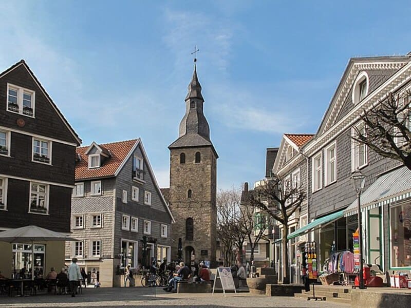 Historischer Stadtkern mit grau verkleideten Fachwerkhäusern und Kirchturm bei sonnigem Wetter in Hattingen.