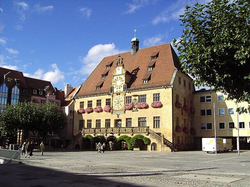 Historisches Rathaus von Heilbronn mit verziertem Uhrturm und Blumen an der Fassade.