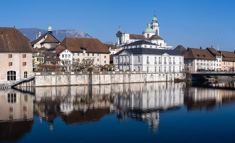 Altstadt von Solothurn mit barocker Kathedrale, historischen Häusern und Spiegelung in der Aare.