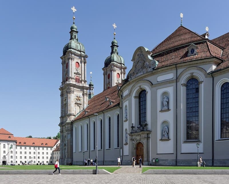 Stiftskirche St. Gallen mit Doppeltürmen, heller Fassade und Besuchern auf dem Vorplatz.