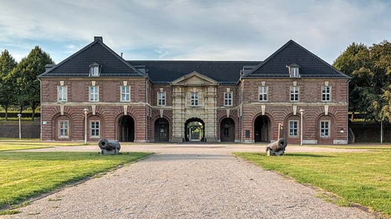 Historisches Torbauwerk in Wesel mit symmetrischer Ziegelfassade und Kanonen im Vorfeld.