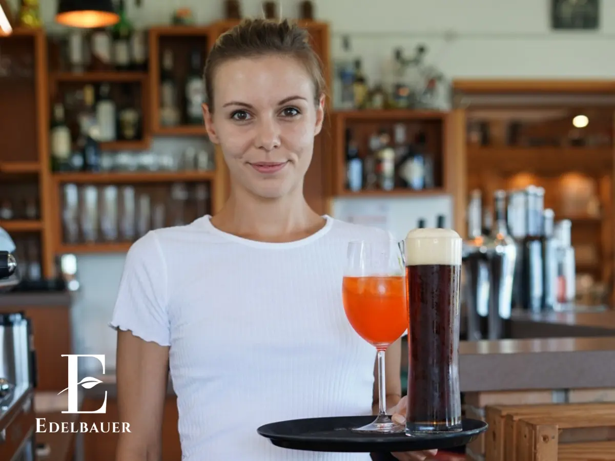 Inhaberin vom Edelbauer mit einem Tablet mit Getränken in der Hand